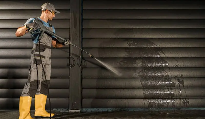 Cleaning personnel that is power washing walls