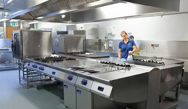 Cleaning crew wiping down a restaurants stainless steel kitchen