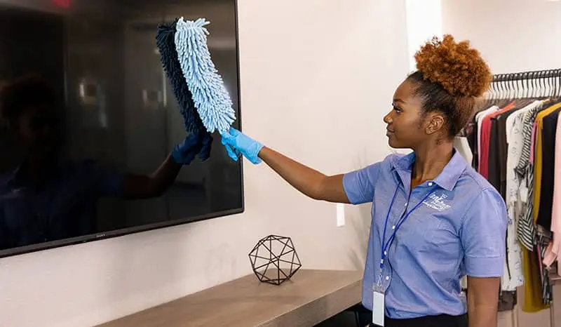 Cleaning personnel wiping down a widescreen TV