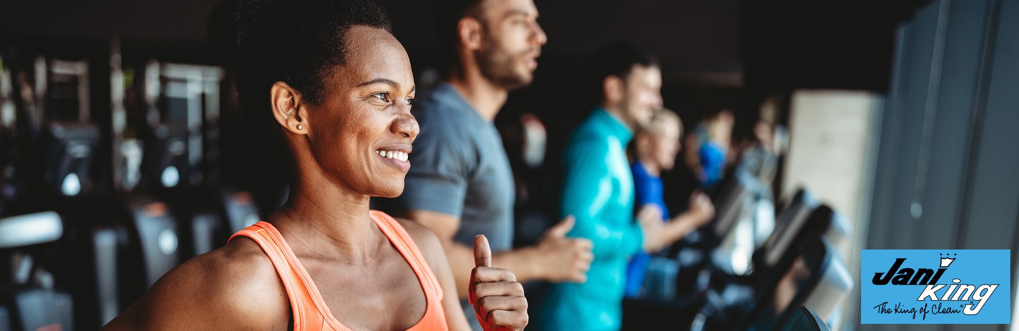 Happy and healthy gym members doing their daily jog on the treadmills.