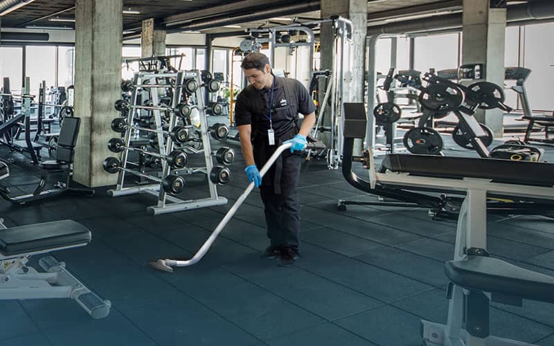 Cleaner at the gym vacuuming