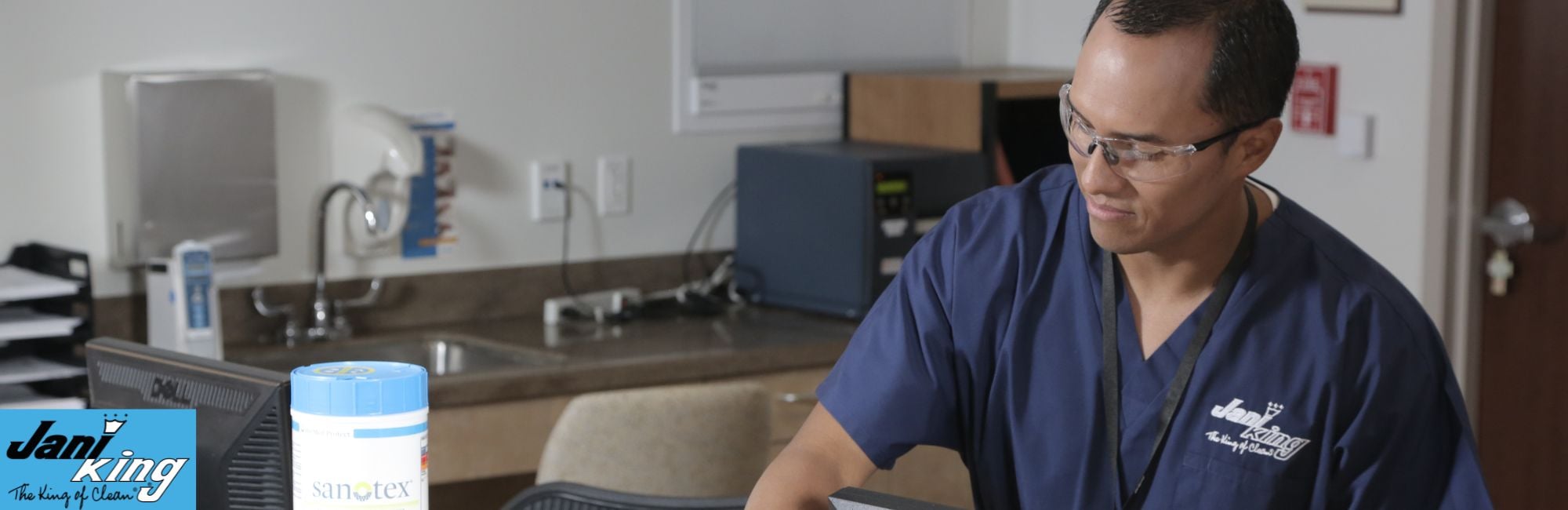 Jani-King employee wiping down hospital desk.