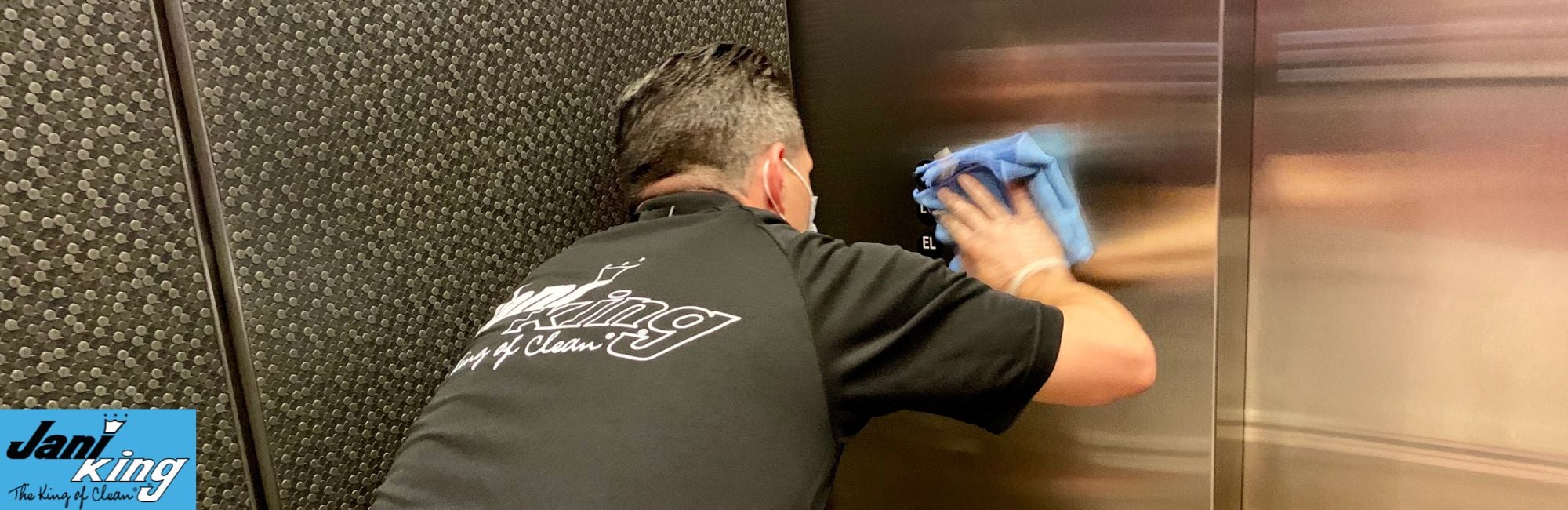 Jani-King employee wiping down an industrial elevator.