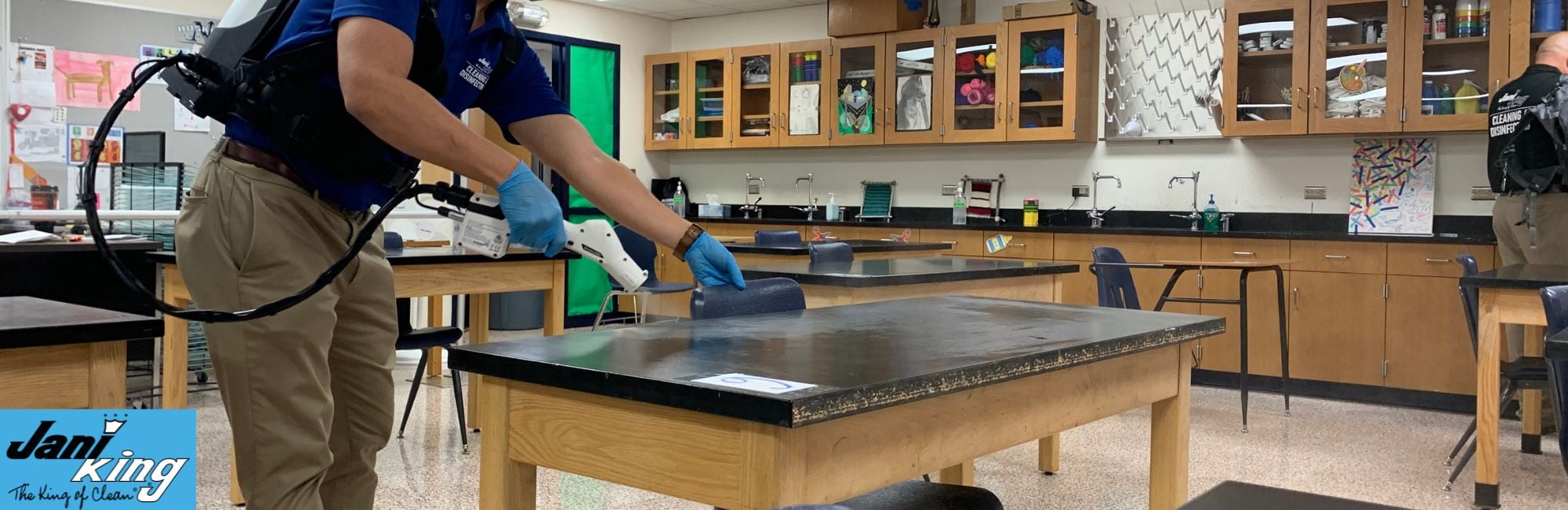Jani-King employee cleaning a school Science room.