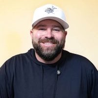 a man with a beard and a green scarf